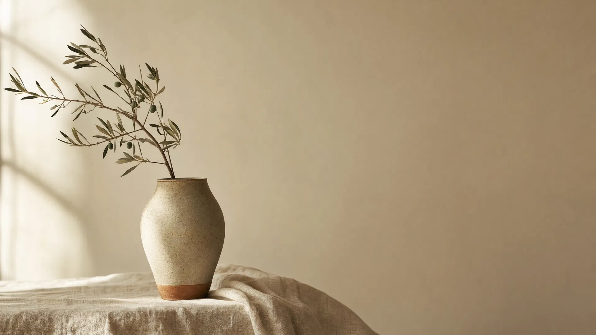 Ceramic vessel with olive branch on linen